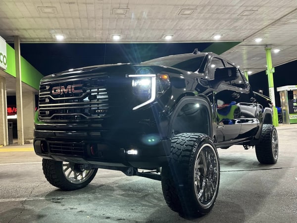 Front view of a white International TerraStar truck with a black dump trailer attached, parked on a concrete lot.